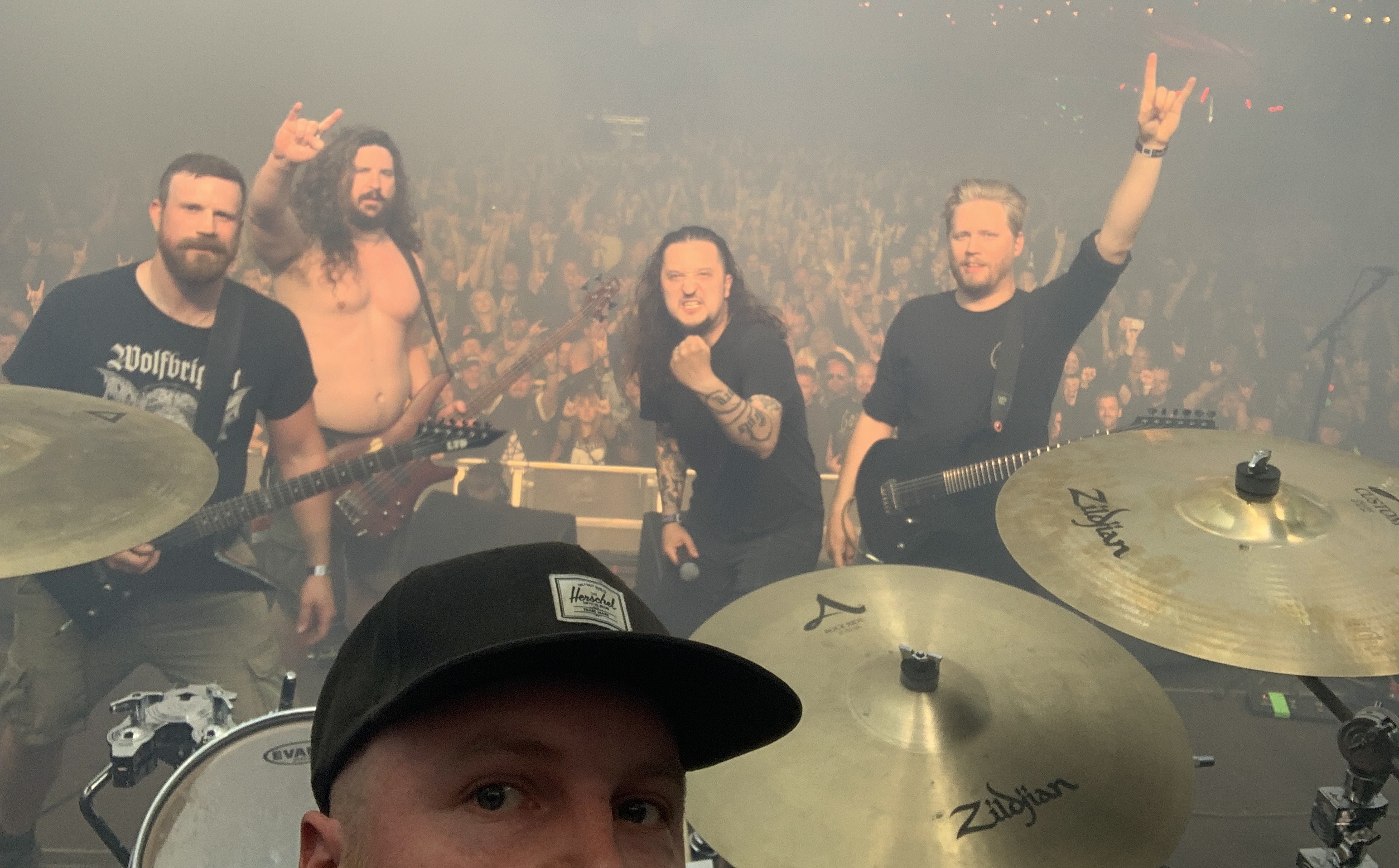 Bandet sitter på scenen med publiken bakom sig.