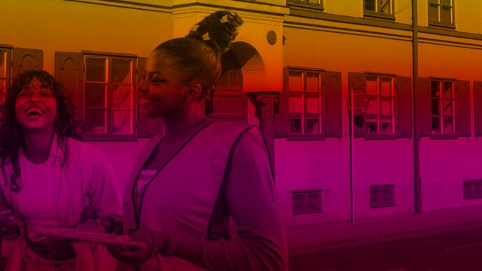 Tv&aring; tjejer skrattar framf&ouml;r ett hus